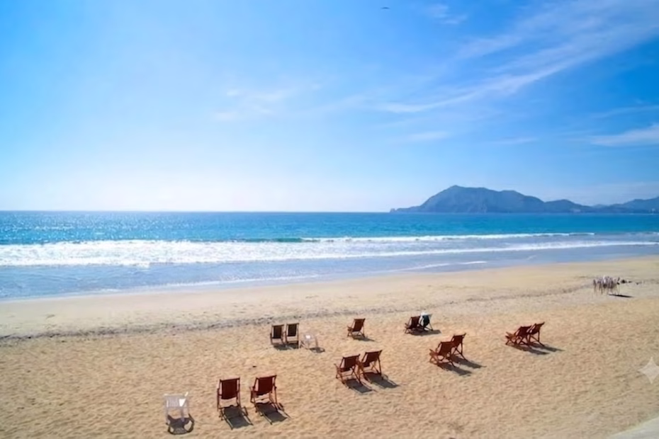Paisaje de playa soleada y tranquila con sillas de descanso frente al mar en la costa de Colima, destino de Rapi2s.