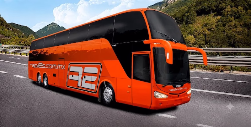 Autobús moderno de dos pisos color naranja de la marca Rapi2s circulando por una carretera, representando viajes seguros hacia el sur de Jalisco y Colima.