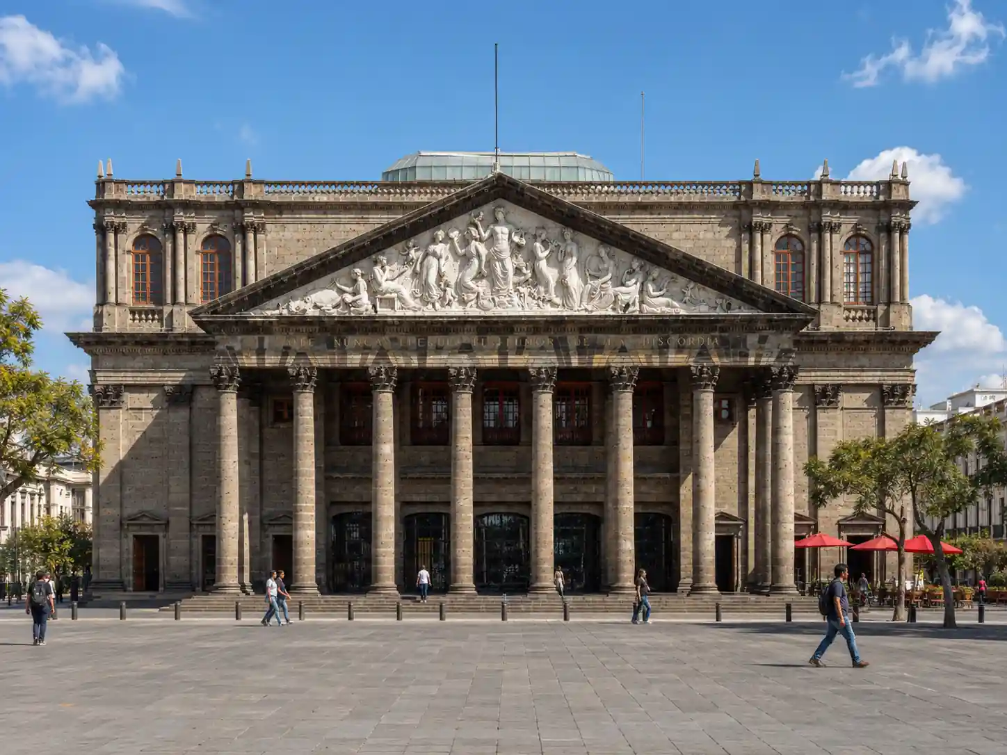 Fachada neoclásica del Teatro Degollado en Guadalajara con columnas de cantera y un relieve escultórico en el frontón.